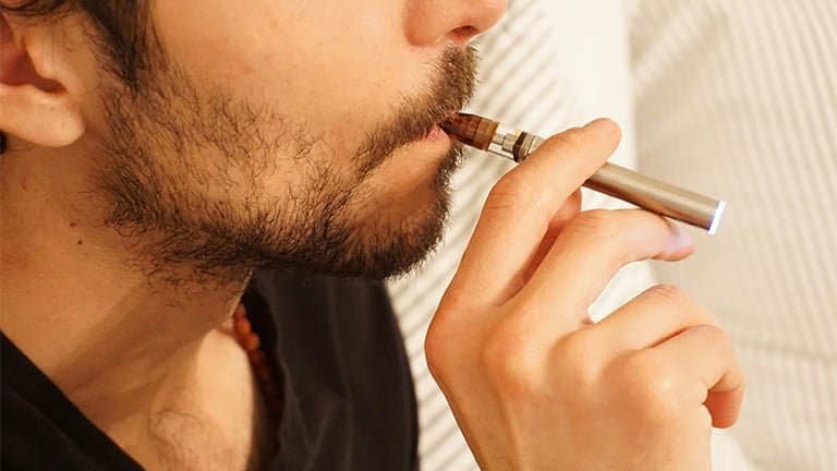 a man smoking a weed pen